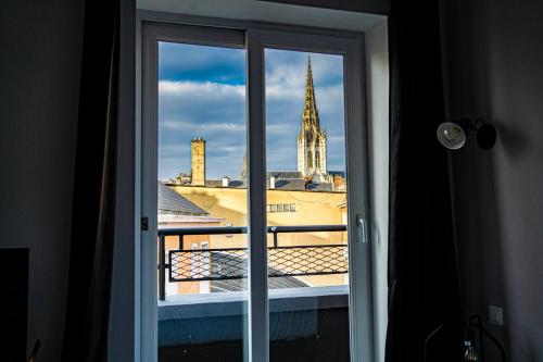 a window with a view of a church at Hotel De Quebec in Rouen