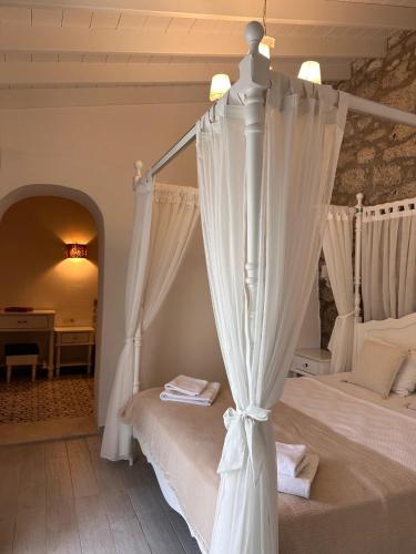 a bedroom with a canopy bed and a desk at Selin Hotel in Alaçatı