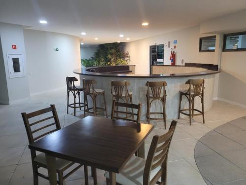 a bar with wooden tables and chairs in a restaurant at Residence Club Praia Dos Anjos vista al mar in Arraial do Cabo