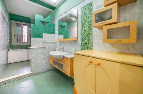 a bathroom with a sink and a toilet and a mirror at 1st floor apartment in the city - air conditioned - wifi in Avola