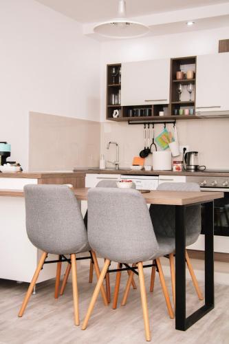 a kitchen with a wooden table and two chairs at Blue Apartment in Sombor