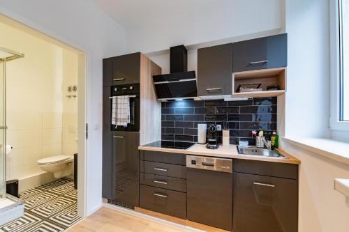 a small kitchen with a sink and a toilet at SweetHome - Studio Apartments, super Zentral, Parkplatz in Eisenach