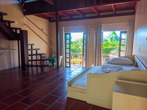 a bedroom with a bed and a large window at Morro do Sol Hotel & Eventos in Porto Belo