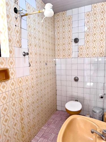 a bathroom with a toilet and a sink at Pousada Vó Celina in Belo Horizonte