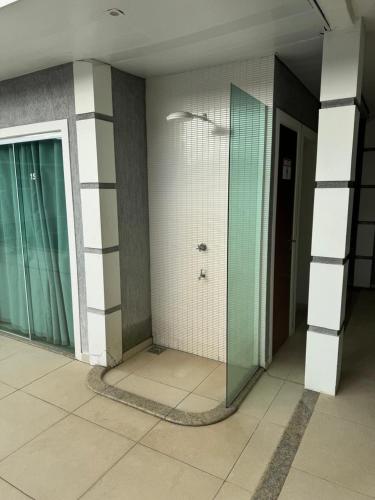 a shower stall in a building with a glass door at Suíte Privativa Completa in Cabo Frio