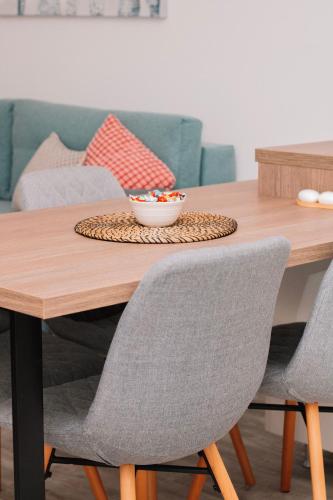 a wooden table with chairs and a bowl on it at Blue Apartment in Sombor