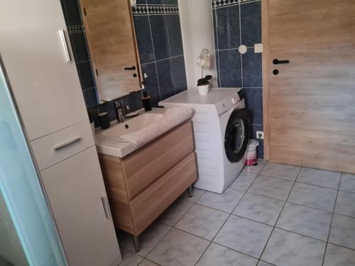 a bathroom with a washing machine and a washer at L occitane in Gimont