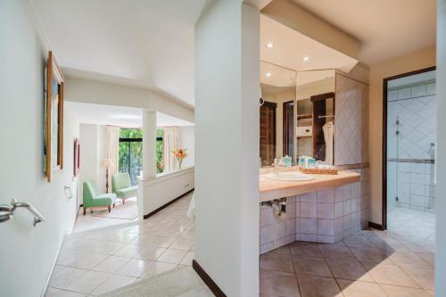 a bathroom with a sink and a mirror at Papagayo Golden Palms Beachfront Hotel in Papagayo, Guanacaste