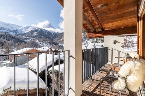 a balcony with a view of a snow covered mountain at Sonnmatten Boutique Hotel & Apartments Zermatt in Zermatt