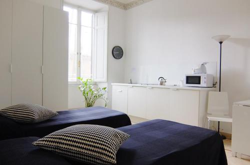 ローマにあるBianco E Nero Apartmentの白い部屋(ベッド2台、キッチン付)