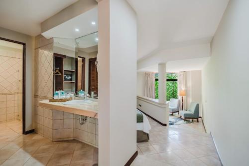 a bathroom with a sink and a mirror at Papagayo Golden Palms Beachfront Hotel in Papagayo, Guanacaste