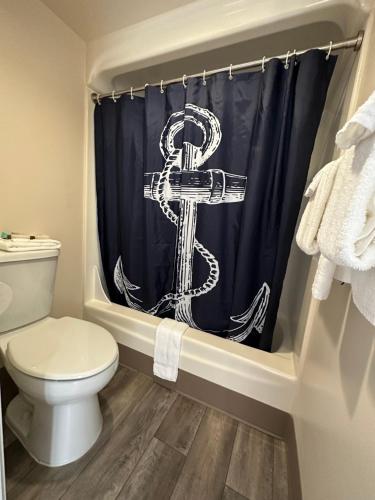 a bathroom with a shower curtain with a anchor on it at Westport Inn in Westport