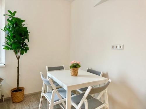 a white table with chairs and a potted plant at Prime Suites near Schönbrunn Castle in Vienna