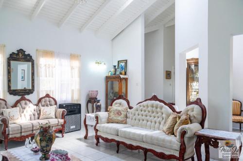 a living room with two couches and a fireplace at Miss J's Vacation Rental in Morne Caillandre