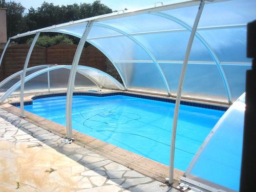 a greenhouse over a swimming pool with a blue water at Casa di Lumio, piscine privée in Lumio
