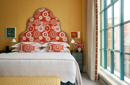 a bedroom with a large bed with a red headboard at Warren Street Hotel in New York