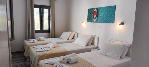a room with three beds with towels on them at Ragousis Apartments in Parikia