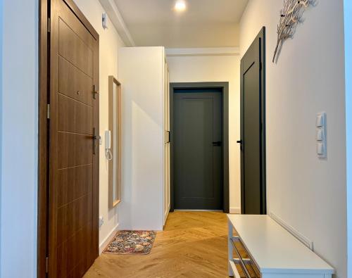 a hallway with two doors and wooden floors and a door at W centrum uzdrowiska in Jedlina-Zdrój