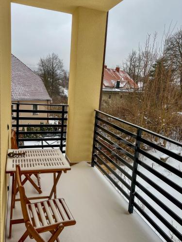 a balcony with a table and two chairs on it at W centrum uzdrowiska in Jedlina-Zdrój
