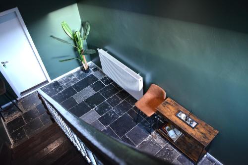 a table with a chair and a plant on it at L'Escapade Rétro in Namur