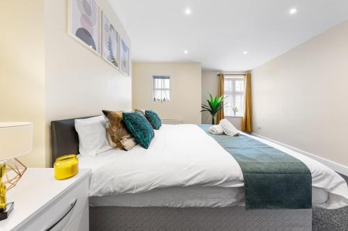 a bedroom with a large white bed with pillows at Spacious London 2-Bed Flat with a King Bed-Save on Long Stays-5 Separate Beds- Parking Available! in Barnet