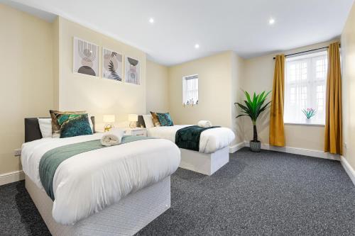 a bedroom with two beds and a window at Spacious London 2-Bed Flat with a King Bed-Save on Long Stays-5 Separate Beds- Parking Available! in Barnet