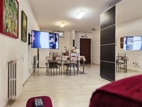 a living room with a table and a tv on the wall at Ballarin Studio Apartment for Business Travels and Holidays in Rome