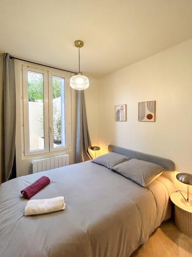 une chambre avec un grand lit et une fenêtre dans l'établissement Les Pins - centre historique, à Montpellier