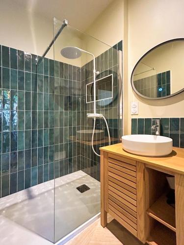 une salle de bain avec une douche avec un lavabo et un miroir dans l'établissement Les Pins - centre historique, à Montpellier