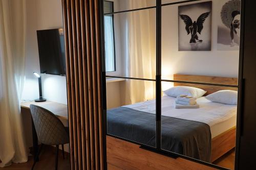 a bedroom with a bed and a desk with a mirror at Simply Apartament - Symfonia z parkingiem in Toruń