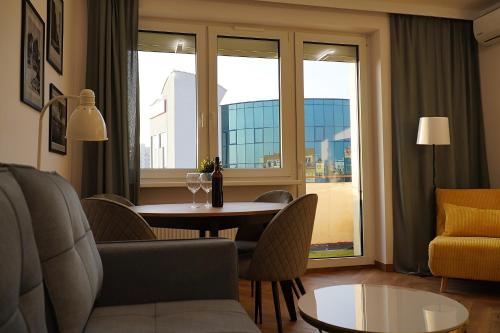 a living room with a table and chairs and a window at Simply Apartament - Symfonia z parkingiem in Toruń