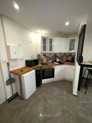 une cuisine avec des armoires blanches et un comptoir dans l'établissement Cozy apartment, à Riom