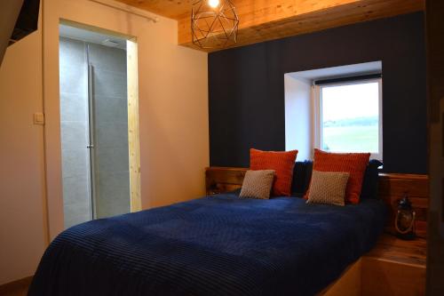 a bedroom with a blue bed and a window at L'Escapade Rétro in Namur
