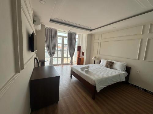 a bedroom with a bed and a desk in it at Crab Bui Vien Homestay in Ho Chi Minh City