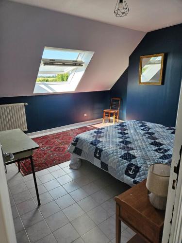 une chambre avec un lit et une lucarne dans l'établissement Jolie Longère Bretonne, à Fréhel