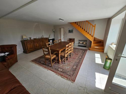 une salle à manger avec une table et des chaises et un escalier dans l'établissement Jolie Longère Bretonne, à Fréhel