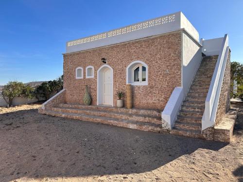 a brick house with stairs and a door at The Mogador's Oasis in Akermoud