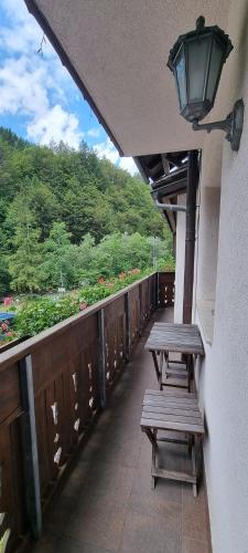 two benches sitting on a train platform with a view at Apartments Pod macesnovo streho in Solčava