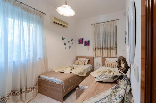 a bedroom with two beds and a window at POUNEDES LUXURY SUITES in Pefki Rhodes