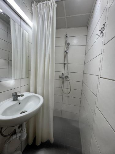 a white bathroom with a sink and a shower at Peaceful Stay in Central Tallinn in Tallinn