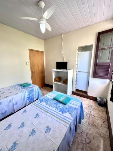 a bedroom with two beds and a ceiling fan at Pousada Vó Celina in Belo Horizonte