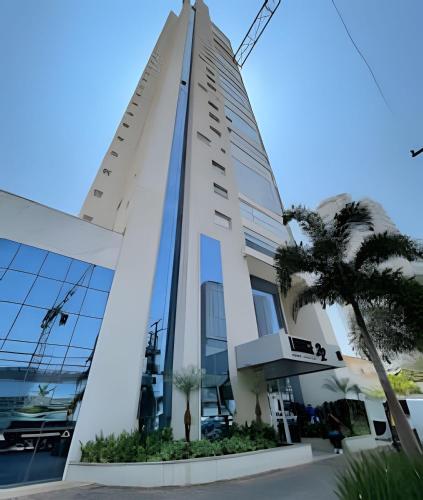 a building with a palm tree in front of it at #1301# Apê 1Q c/ banheira privativa in Goiânia