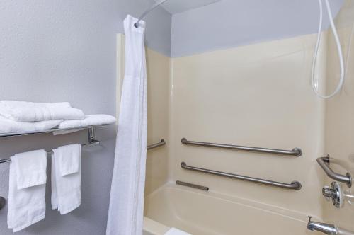 y baño con ducha y toallas blancas. en Microtel Inn & Suites by Wyndham Cordova Memphis I-40 East, en Memphis