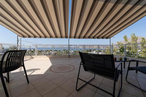 a patio with a table and chairs on a balcony at POUNEDES LUXURY SUITES in Pefki Rhodes