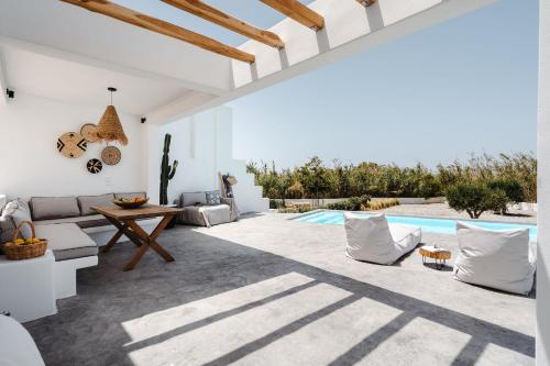 ein Wohnzimmer mit einem Tisch und einem Pool in der Unterkunft Villa isola plaka Naxos in Plaka