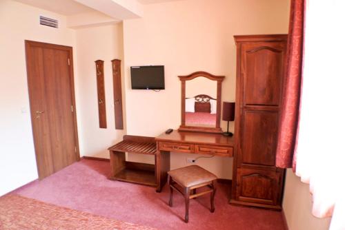 a room with a desk with a mirror and a dresser at Hotel Bozhentsi in Chernevtsi