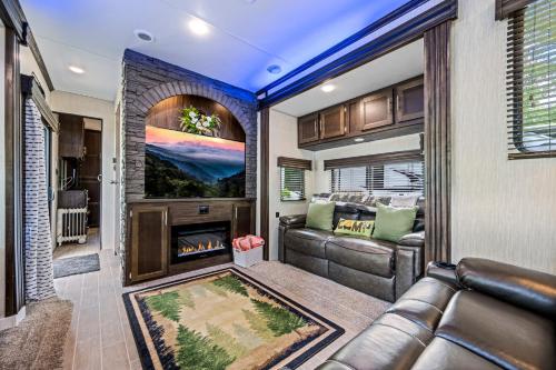 a living room with a couch and a fireplace at Creekside Glamping Resort- Fishing Pond, Mini Golf, Game Room, Pet Friendly in Gatlinburg