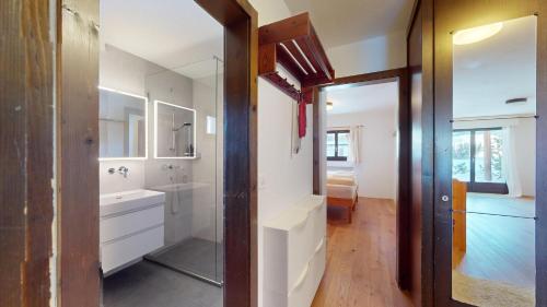 une salle de bain avec un lavabo et un miroir dans l'établissement Crest Alta B15, à Surlej