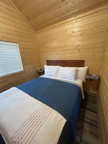 Un dormitorio con una cama en una cabaña de madera. en Tiále Tiny Home, en Cleveland