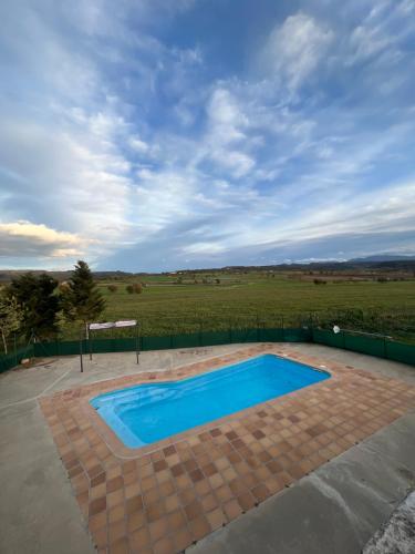 a swimming pool in a patio with a field in the background at Casa Vella del Cuní in Roda del Ter